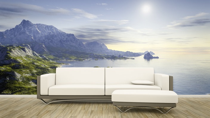 Weißes Sofa vor einer Fototapete mit Meer und Bergen