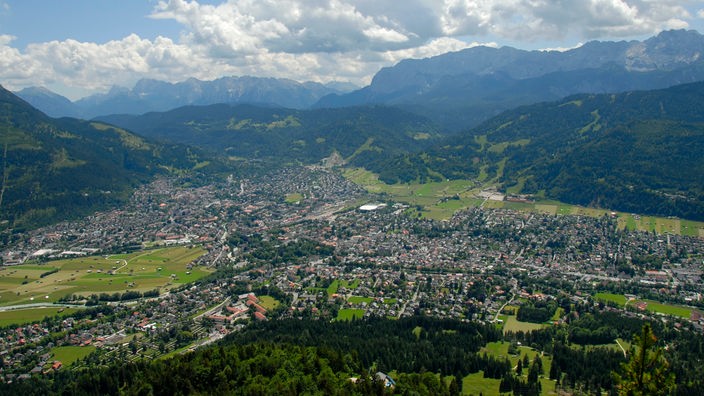 Blick vom Kramer Kramerspitz auf die Stadt Garmisch-Partenkirchen, Zugspitze und Wettersteingebirge hinten.