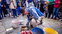  Der Kölner Künstler Gunter Demnig verlegt Stolpersteine in Gedenken an Opfer des Nationalsozialismus.