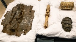 Vier Artefakte im Horniman Museum and Garden auf einem weißen Tuch.