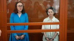 Jewgenija Berkowitsch (r.) und Swetlana Petrijtschuk vor einer Gerichts-Anhörung mit Handschellen in einem Glaskäfig.