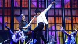  Musical-Darsteller Benet Monteiro (M) als Michael Jackson tanzt und singt zu dem Song «Beat It» während eines Fototermins zum Musical "MJ - Das Michael Jackson Musical" im Stage Theater an der Elbe. 