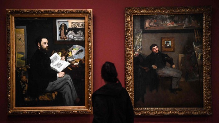 Ein Besucher schaut sich Werke von Edouard Manet (1832-1883), "Portrait of Emile Zola" (L) und  Edgar Degas (1834-1917), "Portrait of the painter James Tissot", in der Ausstellung "Manet/Degas" im Orsay Museum in Paris am 24.03.2023 an.