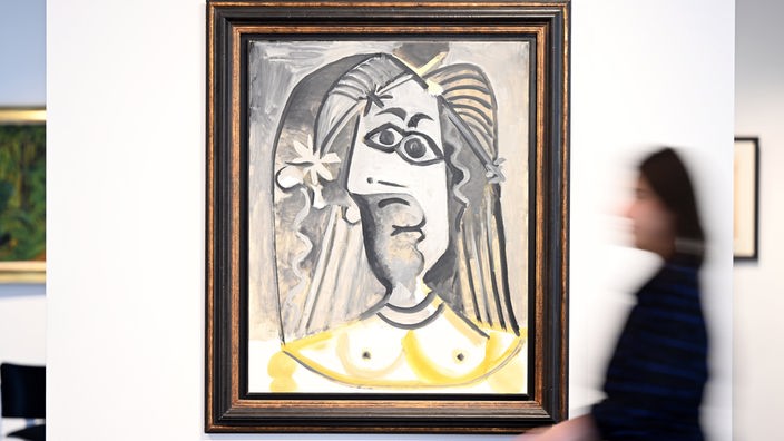 Eine Mitarbeiterin des Auktionshaus Van Ham geht am Bild «Buste de femme» aus dem Jahr 1971 von Pablo Picasso vorbei.
