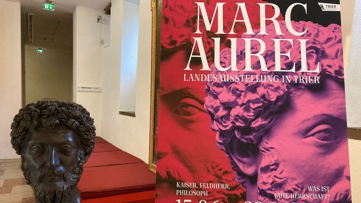 Die Replik eines Porträts vom römischen Kaiser Marc Aurel und ein Plakat weisen auf die rheinland-pfälzische Landesausstellung "Marc Aurel" hin.