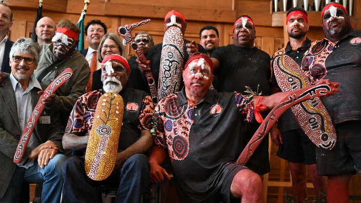 Ned Jampitjinpa Hargraves und andere Mitglieder der Warlpiri-Gemeinde Yuendumu in traditioneller Bemalung mit Bernolf Eibl-Eibesfeldt bei einer Übergabe-Zeremonie von Bumerangs, Speeren und Schilden.