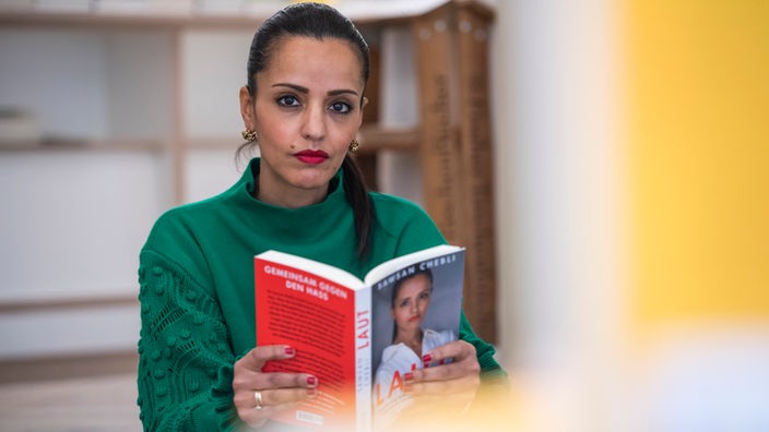 Sawsan Chebli (SPD) sitzt mit ihrem Buch "Laut" in einer Buchhandlung. 