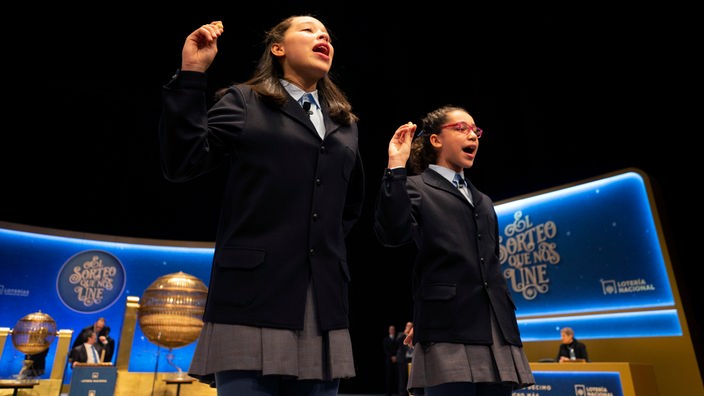 Zwei Schülerinnen tragen 2019 im Opernhaus Teatro Real die gezogenen Losnummern und die Höhe der jeweiligen Gewinne der traditionellen Weihnachtslotterie «El Gordo» (Der Dicke) singend vor. 