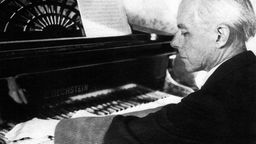 Béla Bartók am Flügel sitzend, seitlich fotografiert