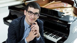 Der Pianist Giorgi Gigashvili sitz vor seinem Flügel