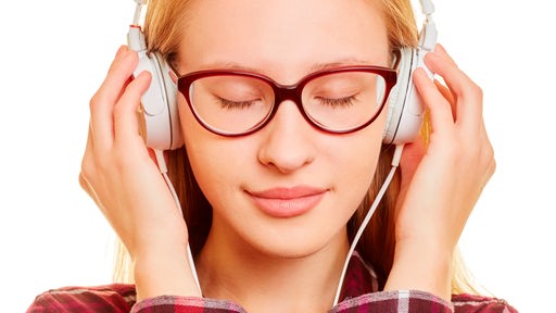 Junge Frau hört Musik über Kopfhörer mit Augen zu
