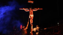 Nachstellung der Kreuzigung, Neapel, Jesus am Kreuz im Feuerschein