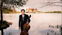 Jan Vogler mit seinem Cello, im Hintergrund das Schloss Moritzburg