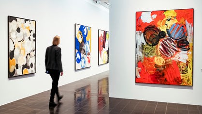 Eine Frau geht durch die Ausstellung "Ernst Wilhelm Nay. Retrospektive" in der Hamburger Kunsthalle.