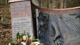 An der Gedenkstätte für das Konzentrationslager Kemna in Wuppertal (Nordrhein-Westfalen) steht ein Kranz.