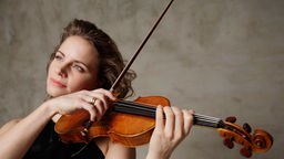 Die Geigerin Julia Fischer spielt Geige und blickt verträumt in die Ferne.