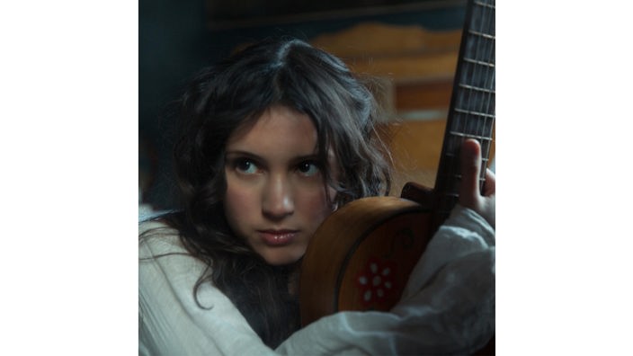 Porträt der Sängerin Liana Flores mit einer Gitarre.