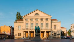 Deutsches Nationaltheater und Staatskapelle Weimar am Theaterplatz am Morgen bei Sonne und blauem Himmel.