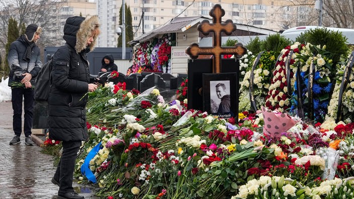 Eine Frau legt einen Tag nach der Beerdigung von Alexej Nawalny auf dem Borisowskoje-Friedhof Blumen am Grab ab.