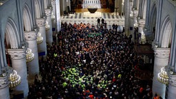 Hunderte von Handwerkern und Präsident Emmanuel Macron stehen in der frisch restaurierten Pariser Kathedrale Notre-Dame.