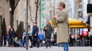 Ingolf Lück, Schauspieler, Moderator, Komiker, spielt in der Kölner Innenstadt Saxophon.