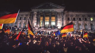 Menschen feiern am 3. Oktober 1990 vor dem Berliner Reichstag die wiedergewonnene Einheit