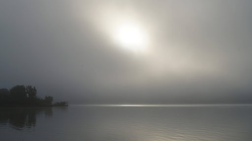 Nebelstreifen am Horizont über einem See