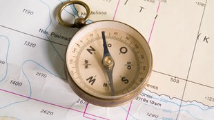 Ein Kompass liegt auf einer Seekarte