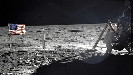 Foto der ersten Mondlandung von Apollo 11 mit einer gehissten amerikanischen Flagge und einem Besatzungsmitglied