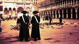 Zwei Soldaten stehen auf einem Platz in Venedig zusammen.