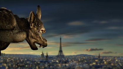 Ein Gargoyle von Notre Dame, im Hintergrund die Stadt Paris.