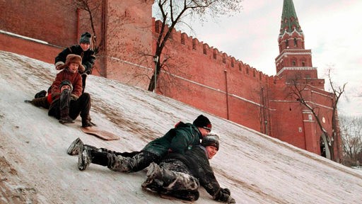 Russische Kinder genießen Wintertage in Moskau, während sie einen vereisten Hügel neben dem Kreml hinunter rodeln, 24. November 1998.