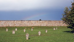 Auf dem ehemaligen Gelände des KZ Mauthausen in Österreich stehen auf einer Wiese Grabsteine zur Erinnerung der Ermordeten.