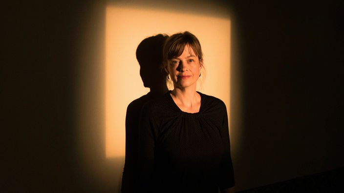 Die Autorin Mariana Leky posiert vor einer beleuchteten Wand.