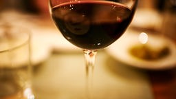 Foto eines Rotweinglases auf einem Tisch.