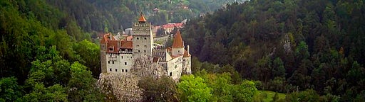 Schloss Bran in Siebenbürgen, mehrere Türme inmitten bewaldeter Hügel