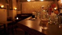 Ein halb geleertes Bier und andere benutzte Gläser stehen kurz nach der Sperrstunde in einer Bar in Neukölln auf dem Tresen.