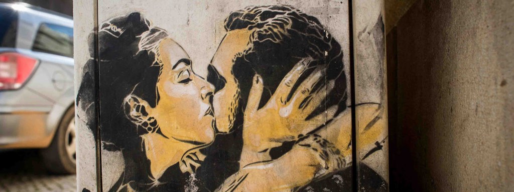 Wandzeichnung zweier sich küssender Menschen.