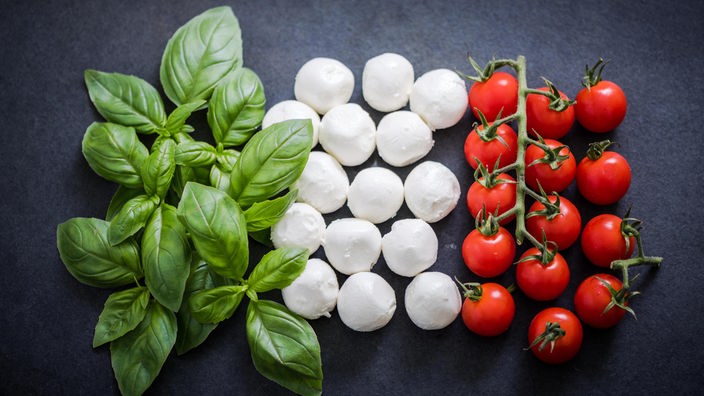 In den Farben der italienischen Flagge: Basilikum, Mozzarella und Tomaten nebeneinander.