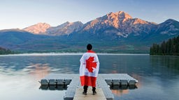 Mann am See, mit umgehängter kanadischer Flagge