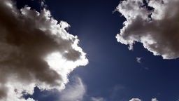 Die Sonne verbirgt sich hinter Cumuluswolken, auch Haufenwolken oder Quellwolken genannt.