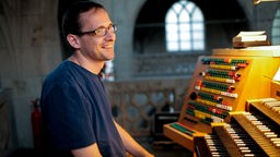 Dominik Susteck sitzt an einer Orgel
