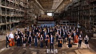 Das Kyiv Symphony Orchestra steht in einer Industriehalle