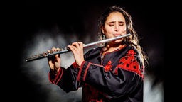 Naissam Jalal spielt auf ihrer Flöte während eines Bühnenauftrittes.