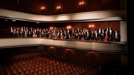 Die Mitglieder des Philharmonischen Orchesters Hagen stehen auf der Empore eines Theaters