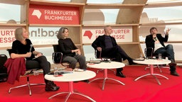 Die Autorinnen und Autoren Francesca Melandri (2.v.l-r), Antonio Scurati und Paolo Giordano sitzen zusammen mit Moderatorin Birgit Schönau auf einem Podium der Frankfurter Buchmesse.