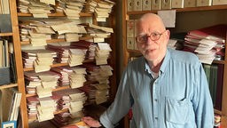 Thomas Przybilka in seinem Krimi Archiv vor Regalen mit Archivunterlagen und Sekundärliteratur zu Krimis.