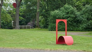 Rote Skulptur der Künstlerin Judith Hopf im Skulpturenpark Köln auf einer grünen Wiese.