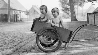 Das Beitragsbild WDR3 "Unverstellte Blicke - Freie Fotografie in der DDR" zeigt ein schwarzweiß Foto von Barbara Wolff "Kinder im Anhänger"