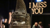 Ein Gedenkkopf aus Kupfer steht vor der Vertragsunterzeichnung zur Rückführung von Benin-Bronzen aus Köln auf dem Tisch. Der Kölner Stadtrat hatte die Rückgabe von 92 Benin-Bronzen aus der Sammlung des Rautenstrauch-Joest-Museums an Nigeria beschlossen.